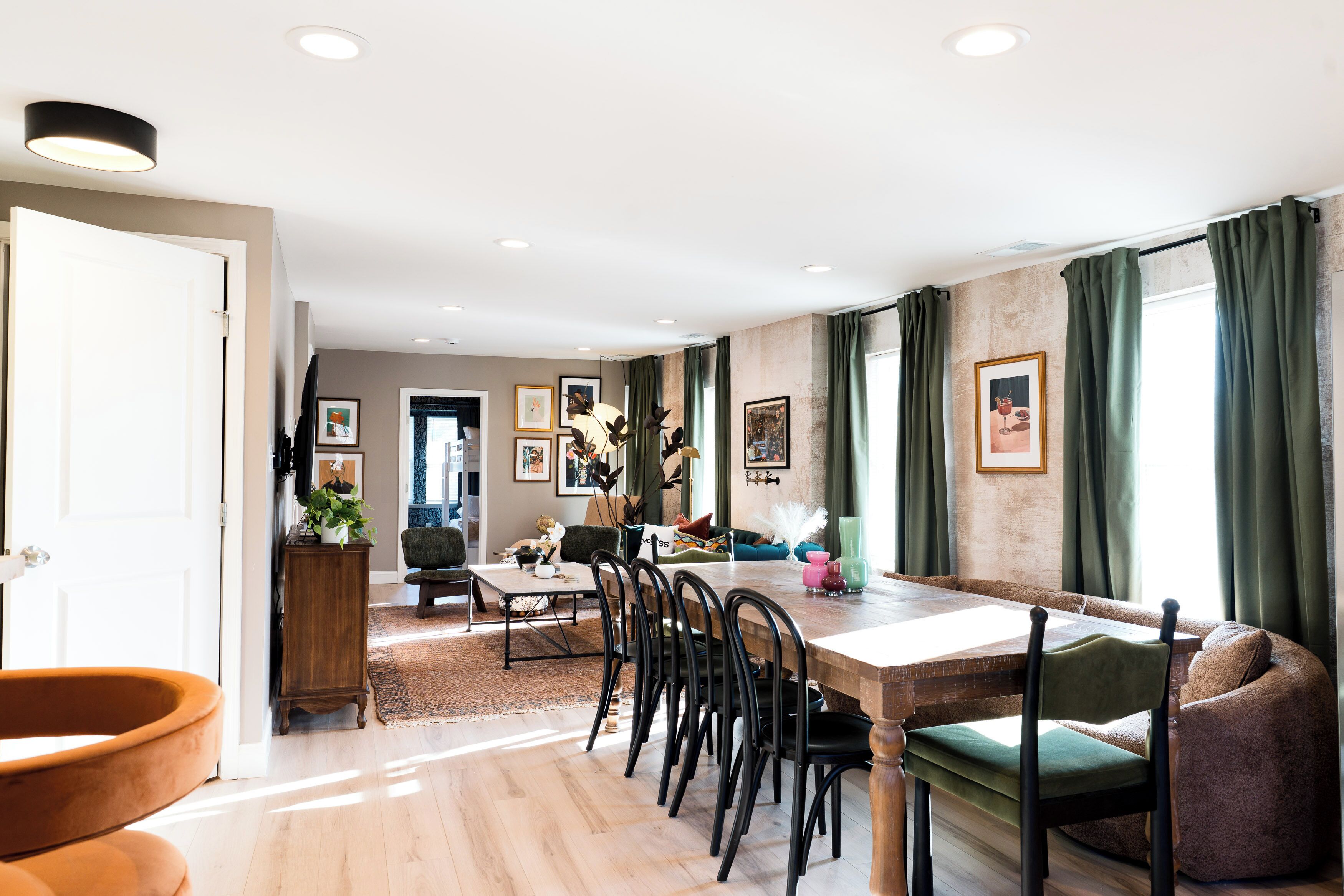 A dining area with a wooden table, chairs, and a sofa.
