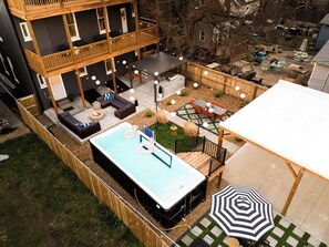 Eine Dachterrasse mit Whirlpool, Sitzgelegenheiten im Freien und Blick auf die Umgebung.