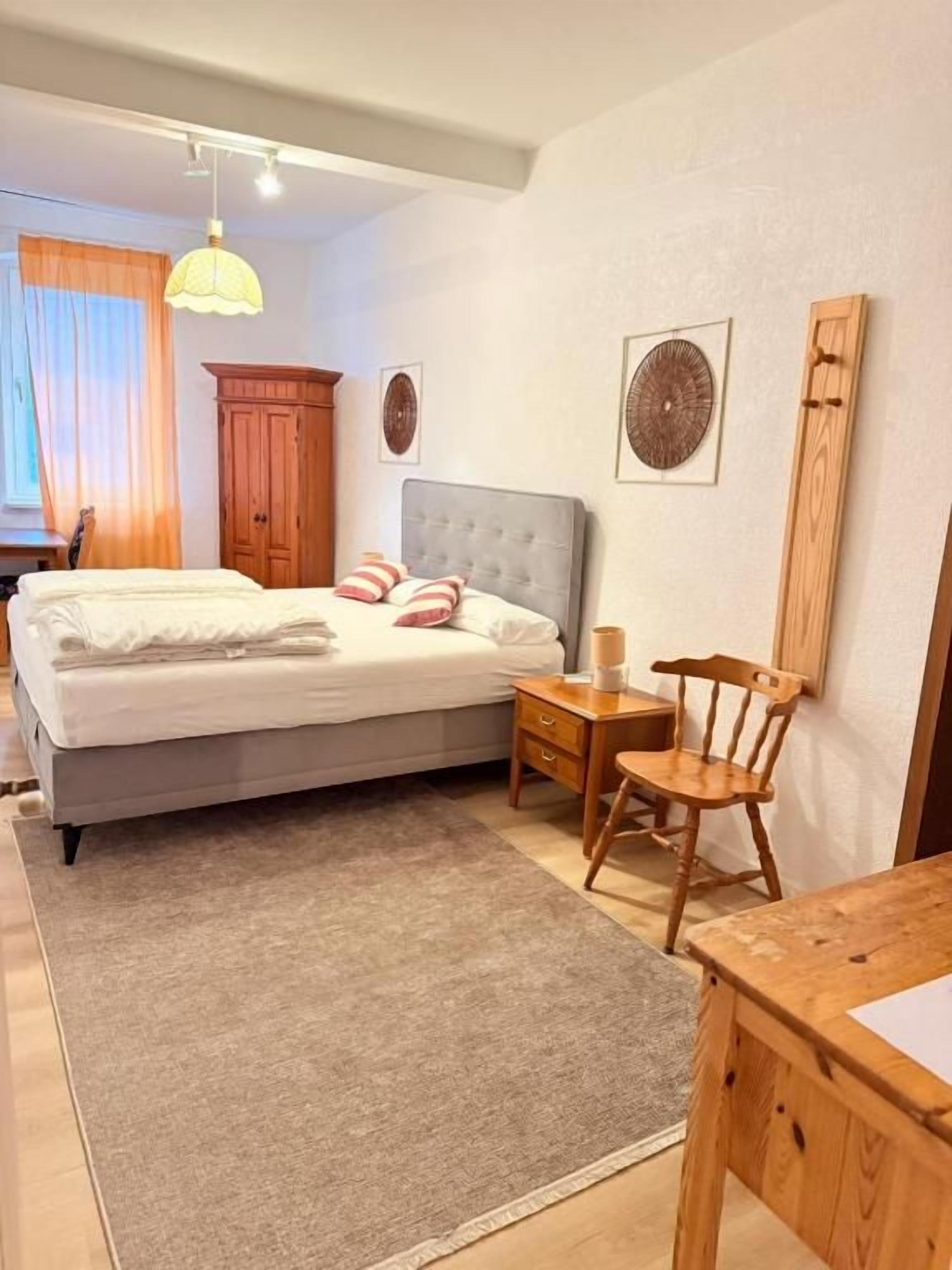 Una camera da letto con un letto, un comodino, una sedia e una scrivania.