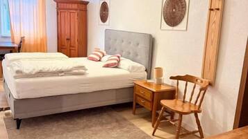 Una camera da letto con un letto, un comodino, una sedia e una scrivania.