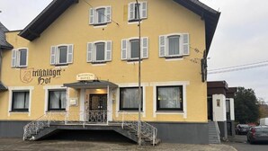 Un edificio amarillo con un cartel que dice 'Frichläger Hof Restaurant Hotel'.