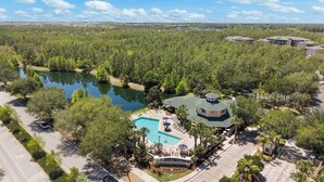 Ein Resort mit Schwimmbad, Laube und Blick auf einen von Bäumen umgebenen See.