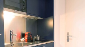 A kitchenette with a stove, sink, and cabinets. - Apartment  by Interhome (Lucerne)