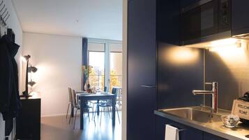A modern kitchen with a built-in oven, a stainless steel sink, and a 'Welcome Home' sign.