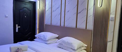 Una habitación de hotel moderna con cama, mesita de noche y teléfono.