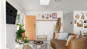 Un salon moderne avec un canapé, une table basse et des plantes en pot.