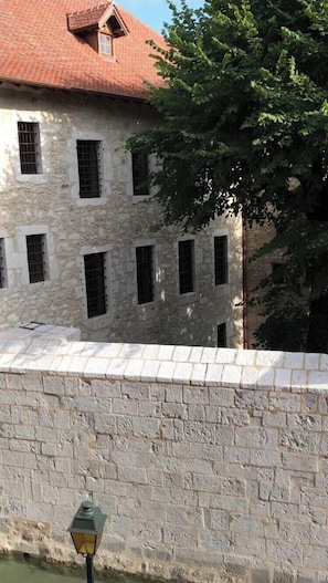 Ein Gebäude aus Stein mit zahlreichen Fenstern und einem roten Ziegeldach.