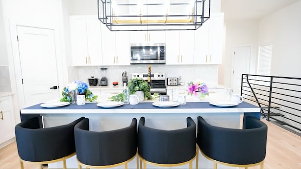 A modern kitchen with white cabinets, a central island with bar stools, a microwave, and a toaster. - 10 Persons Near NRG & Medical Center World Cup Ready, W/Sauna, Spa Atmosphere!!! (Houston)