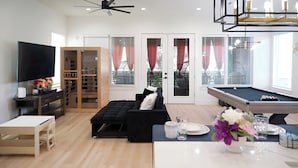 A modern living room with a flat-screen TV, a pool table, a sofa, and a dining area. - 10 Persons Near NRG & Medical Center World Cup Ready, W/Sauna, Spa Atmosphere!!! (Houston)