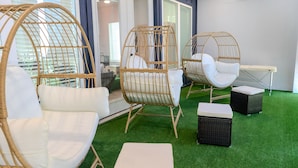 A room with wicker chairs, a small table, and a green artificial turf floor. - 10 Persons Near NRG & Medical Center World Cup Ready, W/Sauna, Spa Atmosphere!!! (Houston)