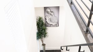 A staircase with dark wooden steps, white walls, a potted plant, and a framed artwork. - 10 Persons Near NRG & Medical Center World Cup Ready, W/Sauna, Spa Atmosphere!!! (Houston)