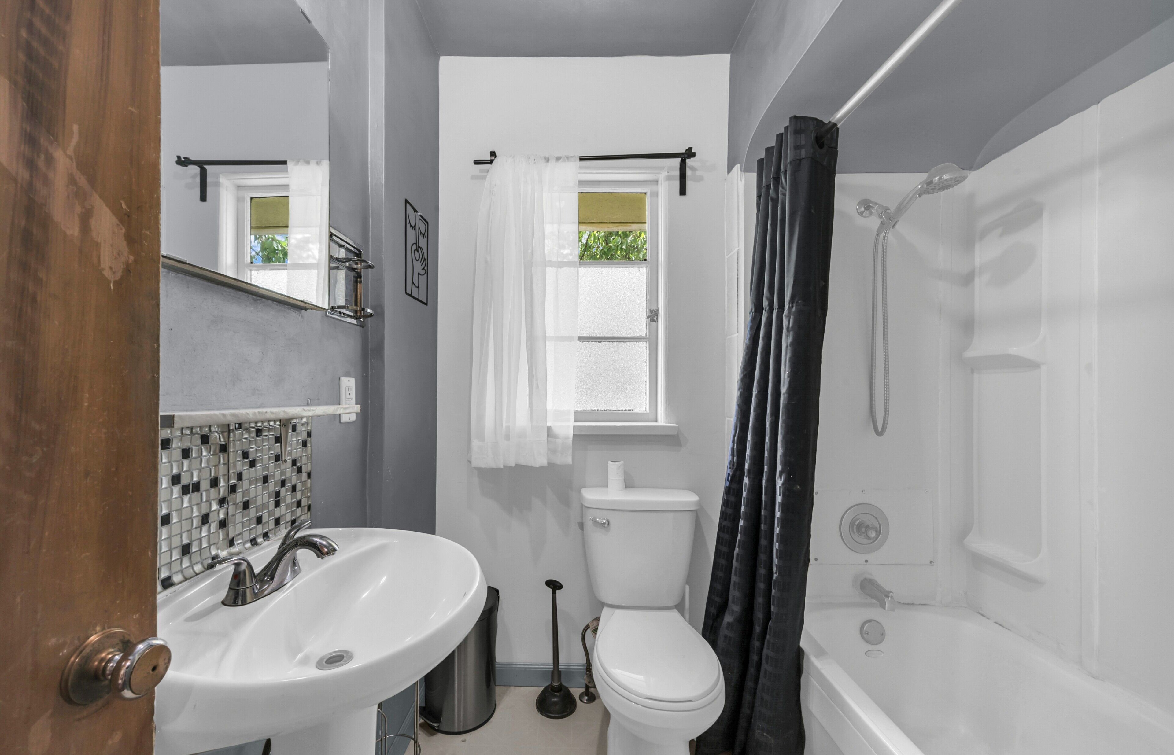 A bathroom with a white sink, toilet, and bathtub.