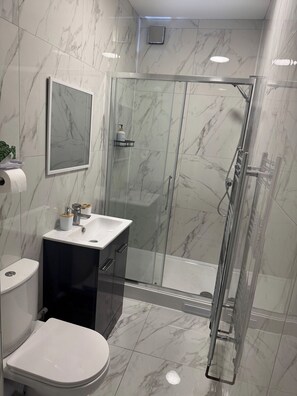 A bathroom with a toilet, sink, and shower area. - Home In Bedford Fast Wifi | Parking |Contractors (Bedford)