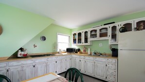 Una cocina con armarios blancos, un microondas y un refrigerador.