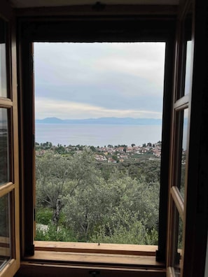 A window with a view of a town and mountains.