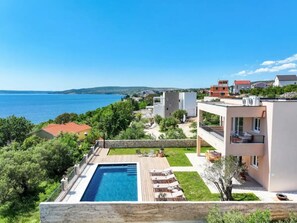 A modern villa with a swimming pool, outdoor seating, and a view of the sea. - Seaview Villa Grota with a heated pool by Interhome (Rovanjska)