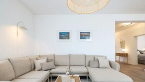 Un salon moderne avec un canapé d’angle, une table basse et deux tableaux encadrés accrochés au mur.