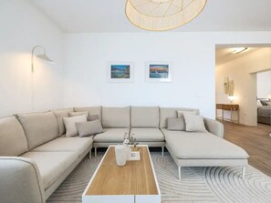 Ein modernes Wohnzimmer mit einem Ecksofa, einem Couchtisch und zwei gerahmten Bildern an der Wand.