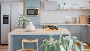 Une cuisine moderne dotée d’un îlot central, d’un four à micro-ondes et d’un réfrigérateur.
