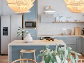 Eine moderne Küche mit Kochinsel, Mikrowelle und Kühlschrank.