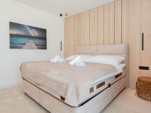 Ein Schlafzimmer mit einem großen Bett, Holzwandverkleidung und einem Bild des Sternenhimmels darüber.