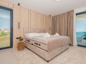 A bedroom with a bed, a potted plant, and a view of the sea. - Seafront Villa Serena with pool and seaview by Interhome (Privlaka)