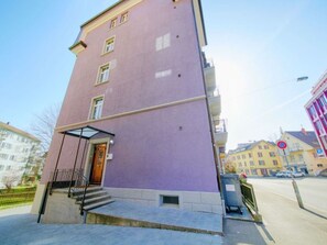 A multi-story building with a purple facade, a visible entrance with steps, and a small balcony. - ZH Blueberry lll - Oerlikon HITrental Apartment by Interhome (Zurich)
