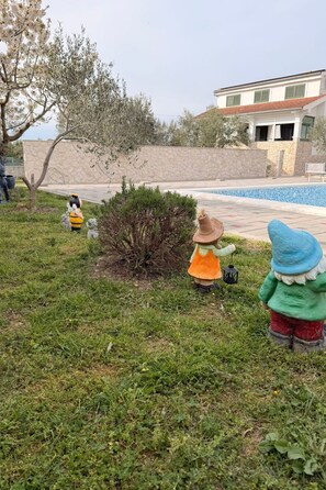 Ein Gartenbereich mit Zwergfiguren und einem Swimmingpool.