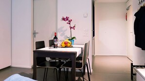 A small dining area with a table set for two, a bottle of wine, and a fruit bowl. - Apartment  by Interhome (Lucerne)