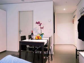 En liten matplats med ett bord dukat för två personer, en flaska vin och en fruktskål.