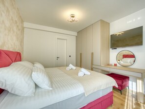 Ein Hotelzimmer mit Bett, Schreibtisch, Spiegel und Tür.