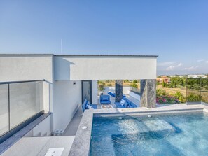 Ein moderner Poolbereich im Freien mit freiem Blick auf die umliegende Landschaft.