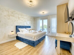Une chambre à coucher avec un lit, une table de chevet et un bureau avec un miroir.