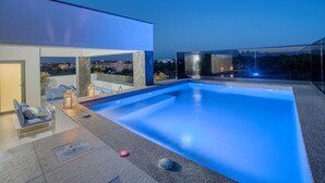 Una piscina esterna moderna con una vista chiara sullo skyline urbano.
