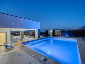 Ein moderner Außenpool mit freiem Blick auf die Skyline im Hintergrund.