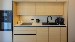 Una cucina moderna con forno integrato, microonde e macchina del caffè.