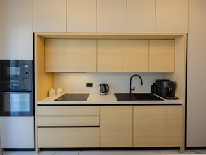 Eine moderne Küche mit Einbauofen, Mikrowelle und Kaffeemaschine.