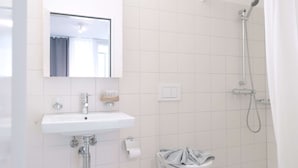 Ein Badezimmer mit Waschbecken, Spiegel und Dusche.
