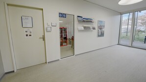 Een hal met een deur, een prikbord en een raam met uitzicht.
