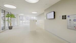 A spacious hallway with a reception desk, a mounted screen, and a control panel. - Apartment  by Interhome (Lucerne)