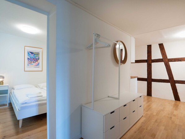 Une chambre à coucher moderne avec un lit, une table de chevet, une commode et un miroir.