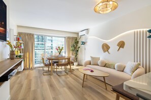 A modern living room with a sofa, coffee table, dining table, and chairs. - Delightful 2-bedroom apartment with AC in vibrant Honolulu (Honolulu)