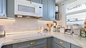 A modern kitchen with a built-in microwave, coffee maker, and toaster. - Delightful 2-bedroom apartment with AC in vibrant Honolulu (Honolulu)