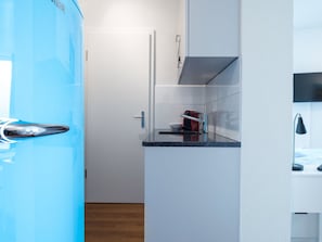 Eine kleine Küche mit einer Mikrowelle, einem kleinen Kühlschrank und einem Spülbecken.