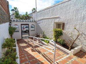A courtyard with a white building, a tiled floor, and a metal railing. - Bajamar Nerja II 7 by Casasol by Interhome (Nerja)