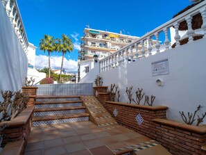 A staircase leading to a building with a white facade, a tiled floor, and a clear blue sky. - Bajamar Nerja II 7 by Casasol by Interhome (Nerja)