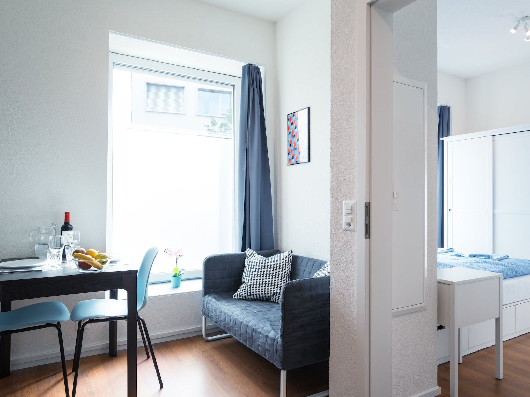 Una habitación moderna con zona de comedor, sofá y cama.