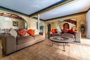 A spacious living area with two sofas, a coffee table, and a chandelier. - Wake up to the sound of waves. Enjoy your 13 m private pool. Watch the sunsets. (Flic en flac)