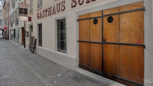 Ein Gebäude mit einem Schild, auf dem 'GASTHAUS SCHIFF' steht, und einer geschlossenen Holztür.