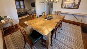A dining area with a wooden table, chairs, a chandelier, and a framed picture on the wall. - 1-4 Guests, 1 Bath Farm Stay at a Pygmy Goat Farm in Byron Center, Michigan (Byron Center)